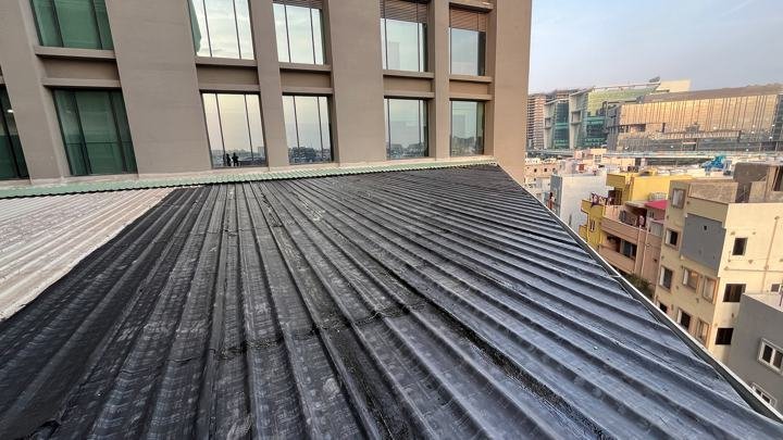 Sheet membrane waterproofing on a roof beside a high-rise building