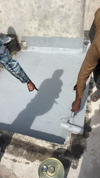 Grey liquid-applied waterproofing coat rolled onto a terrace