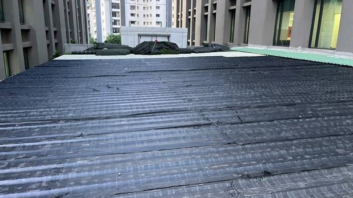 Membrane laid across a commercial building roof deck