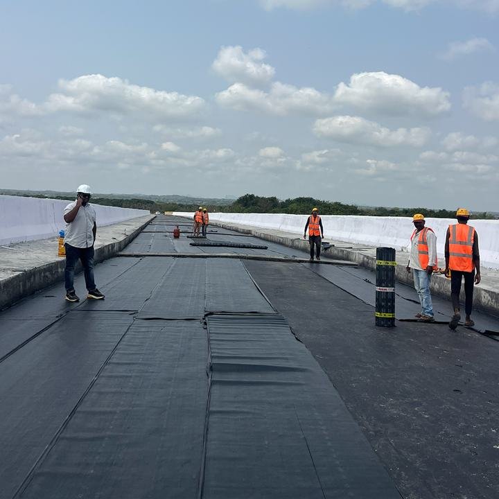 Flat roof with rolls of sheet membrane and the site team