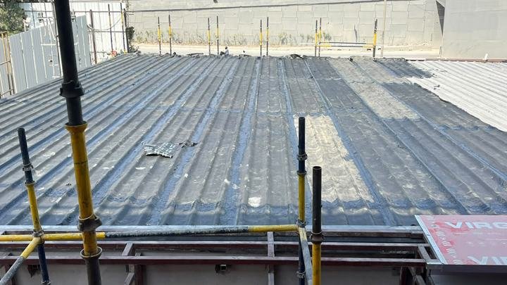 Coated metal roof with edge scaffolding in place
